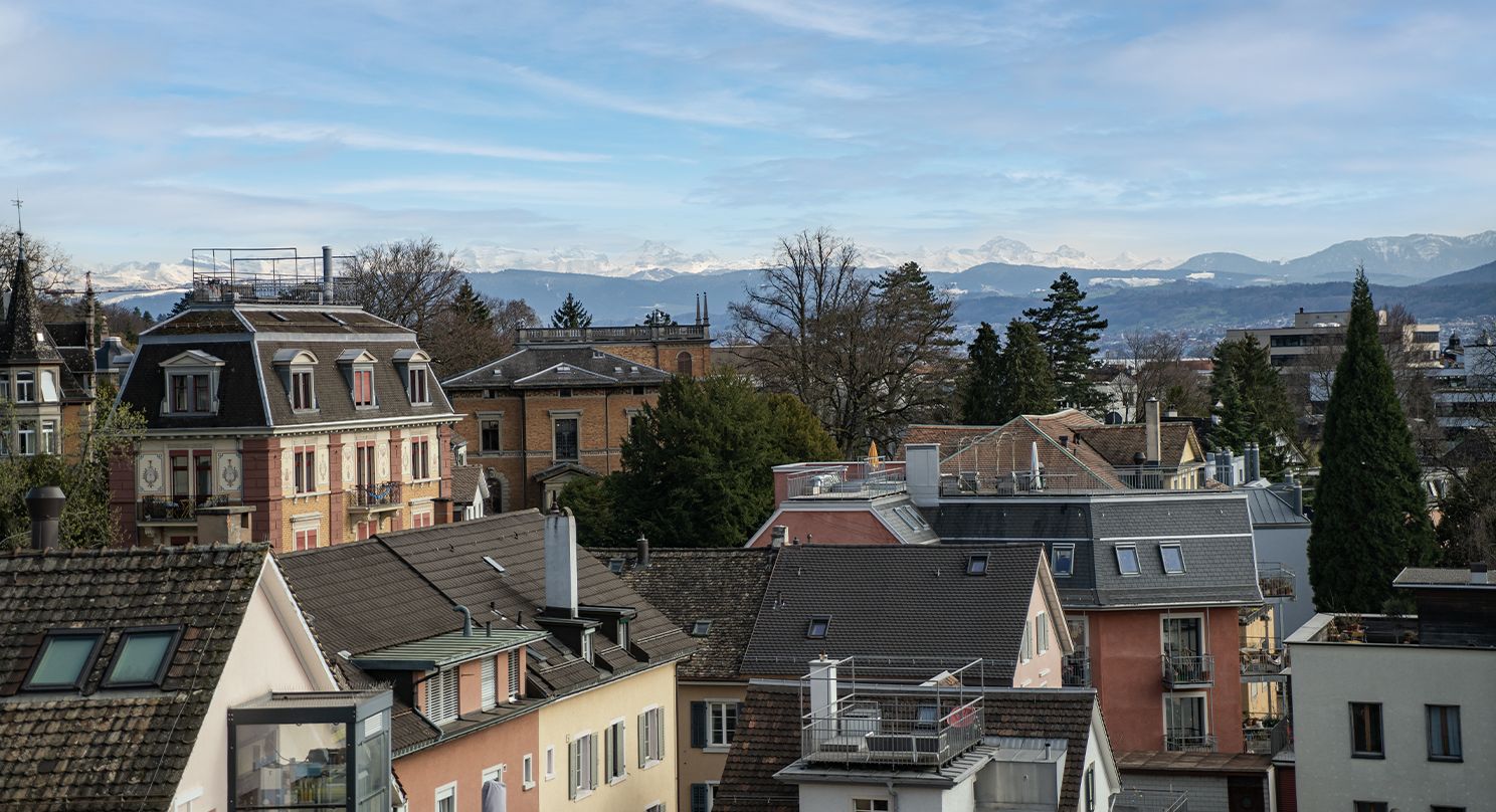 Blick über die Dächer von Zürich, im Hintergrund die Alpen